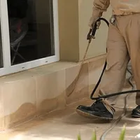 General pest control technician spraying exterior perimeter around a home in Cincinnati, OH